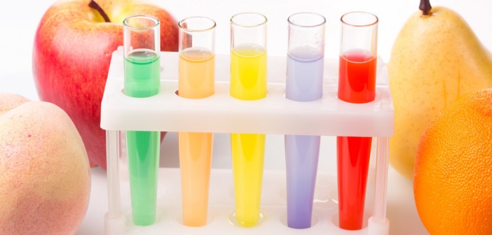 Fruit close chemical test tubes. Genetic Engineering. pesticides in foods. White background.