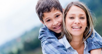 Portrait of a happy mother and son smiling outdoors