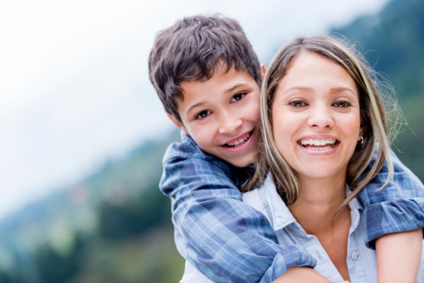 Portrait of a happy mother and son smiling outdoors
