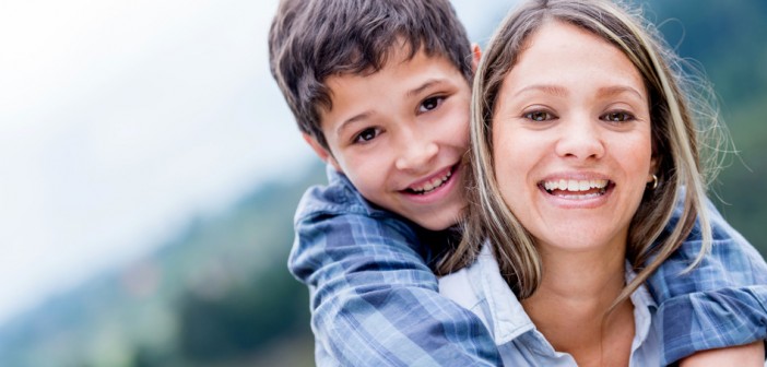 Portrait of a happy mother and son smiling outdoors